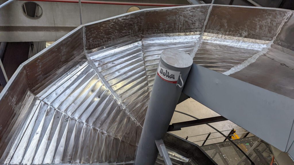 Nahaufnahme der Spiralrutsche aus Stahl mit gekantetem Blech – installiert im Sortierzentrum Herne.