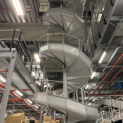 Spiralrutsche aus Stahl mit gekantetem Blech – montiert im Sortierzentrum Herne für effiziente Paketsortierung.